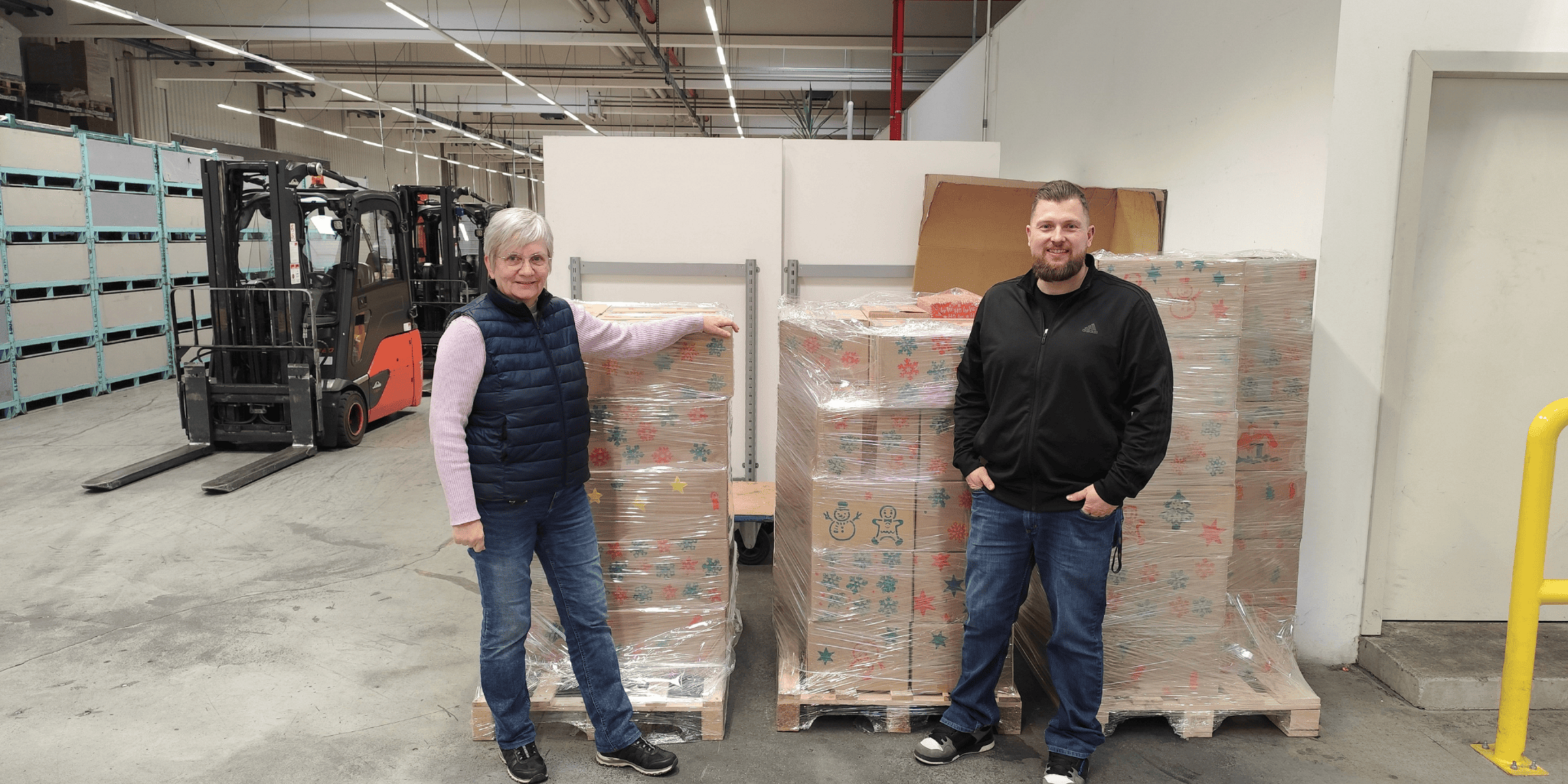 Vertretende des Betriebsrates vor den Päkchen für den Johanniter Weihnachtstrucker