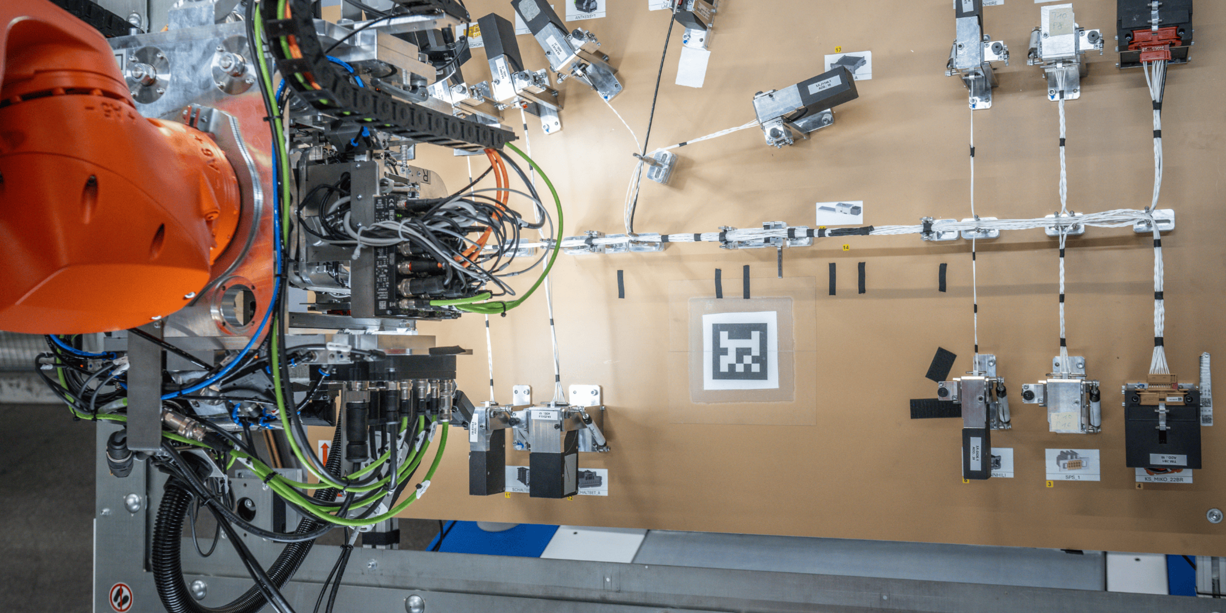 Roboterarm der an einem Bordnetz arbeitet