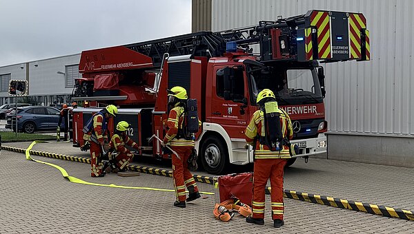 Einsatzkräfte vor dem Feuerwehrauto bei der Evakuierungsübung.