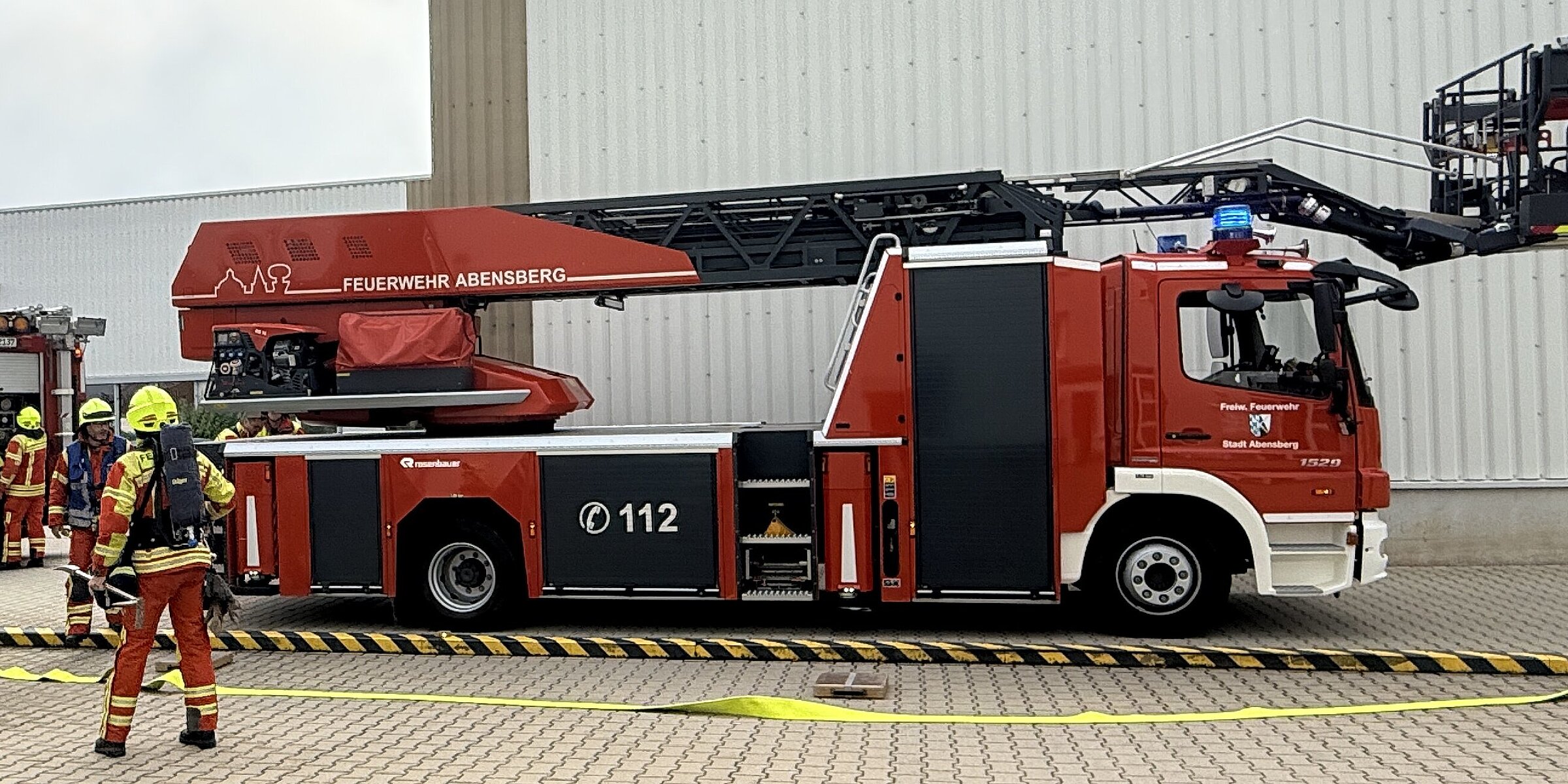Einsatzkräfte vor dem Feuerwehrauto bei der Evakuierungsübung.